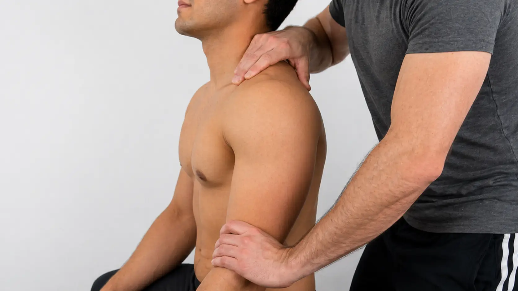 Sulcus sign test demonstrating downward traction on the arm with a visible gap below the acromion, indicating inferior shoulder instability.