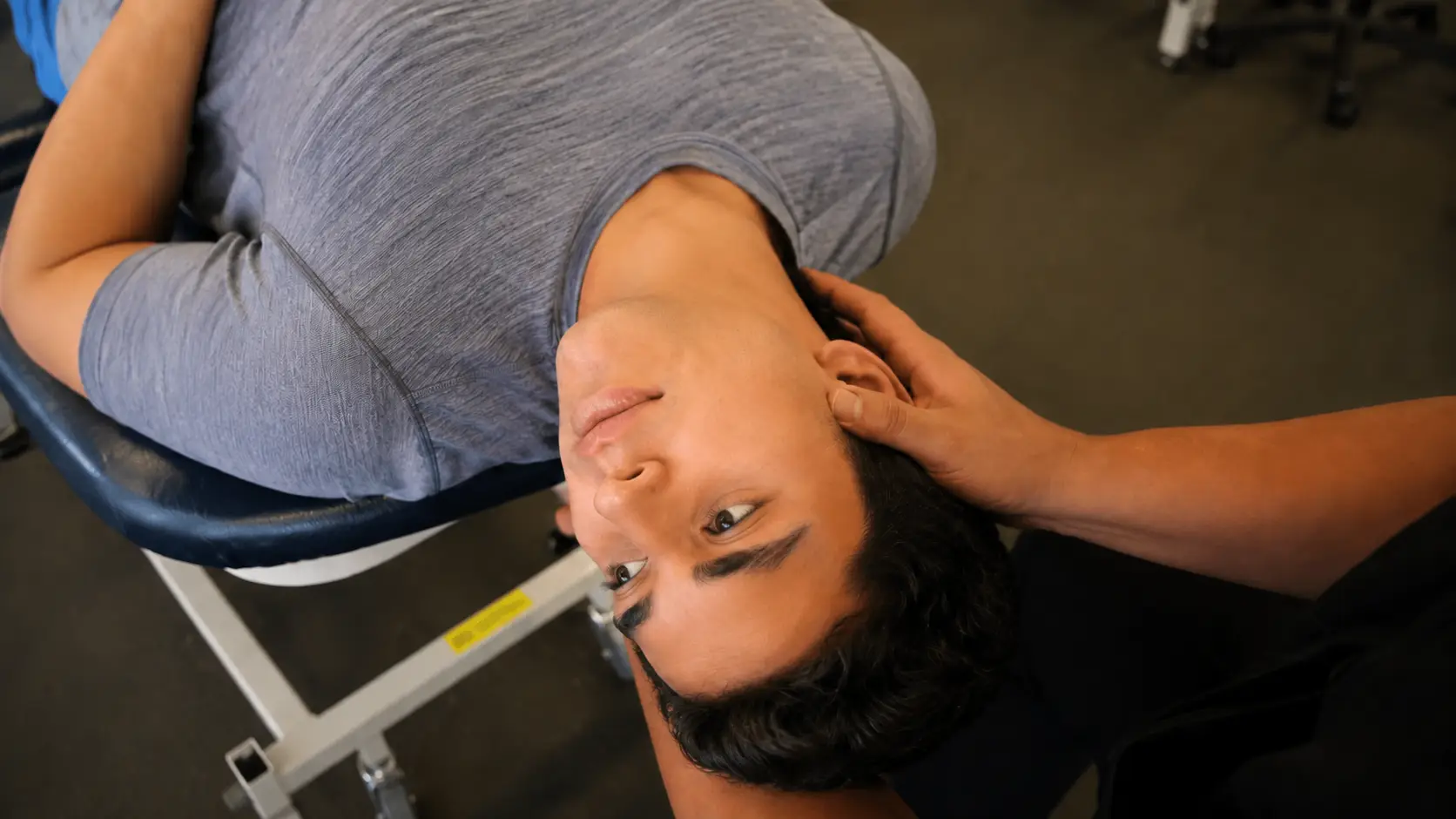 Patient supine with head extended and rotated off table edge.